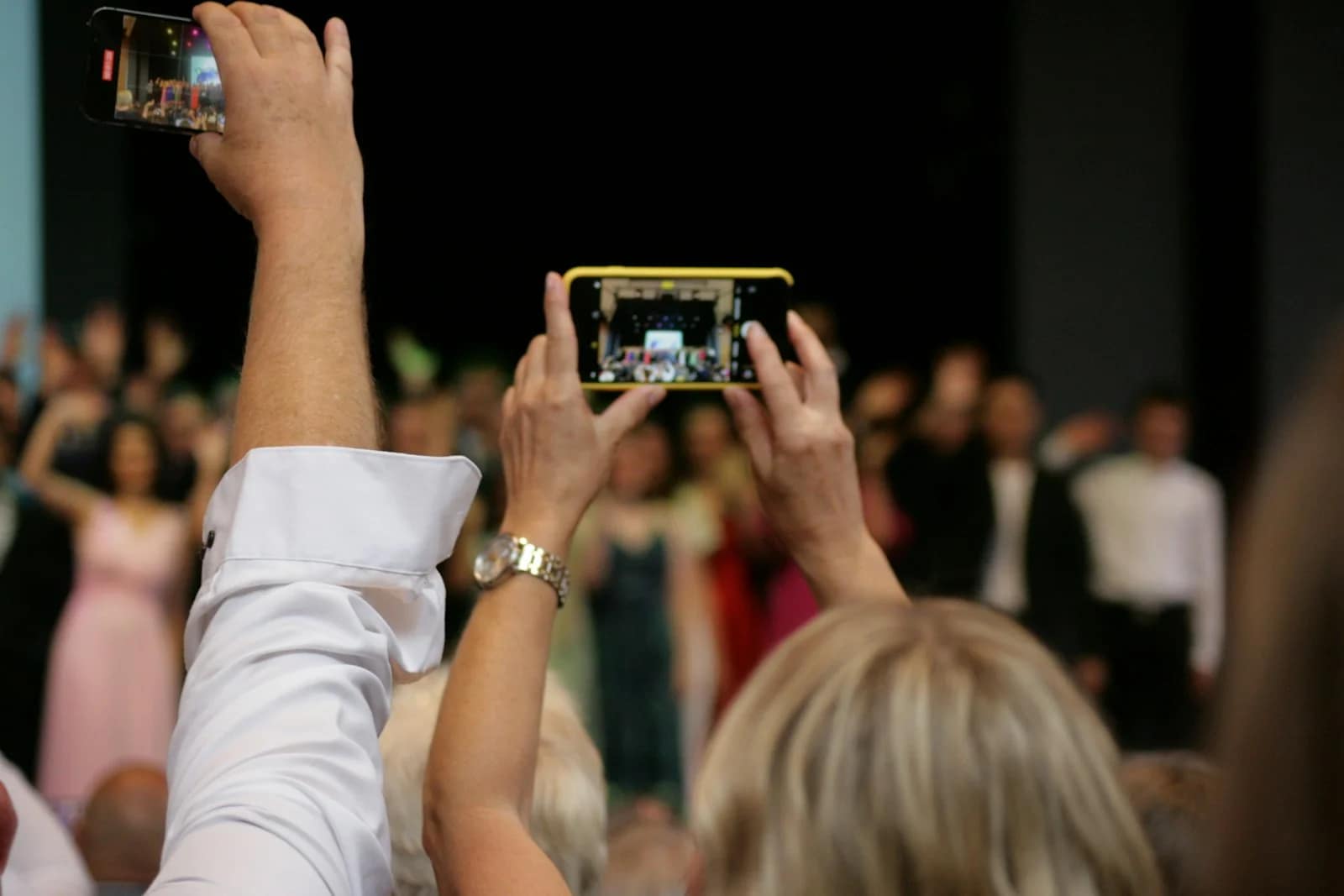 a group of people taking pictures with their cell phones a group of people taking pictures with their cell phones