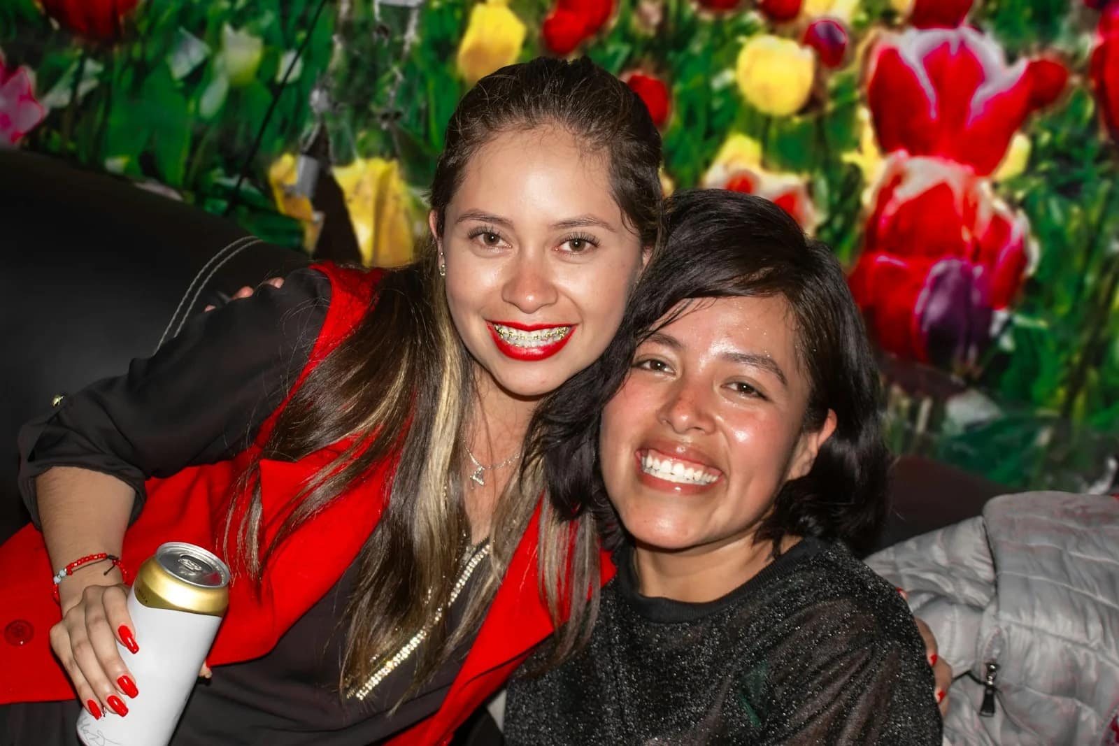 Two smiling women with a colorful floral background Two smiling women with a colorful floral background