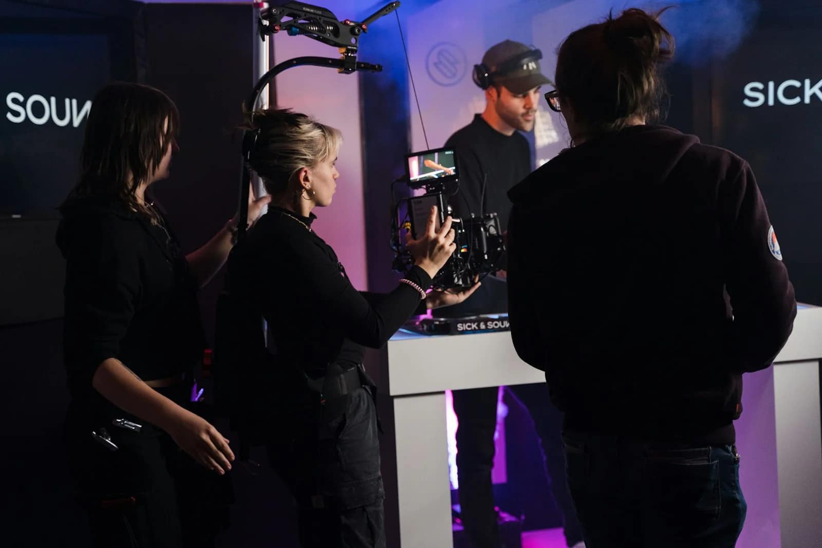 a group of people standing around a table with a camera a group of people standing around a table with a camera